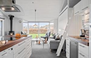 a kitchen with white cabinets and a table and chairs at Cozy Home In Sjølund With Sauna in Sjølund