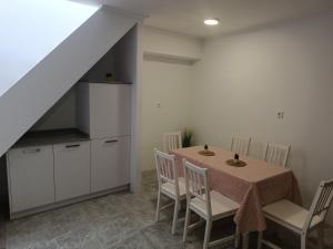 kuchnia i jadalnia ze stołem i krzesłami w obiekcie Vivienda en el casco histórico de Baiona w mieście Baiona