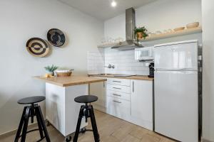 una cucina con frigorifero bianco e 2 sgabelli di Hauzify I Apartament Sunshine Salou a Salou Altre 12 foto