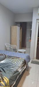 a bedroom with a bed and a table and a chair at Tower Basella no 2025 - Apartemen Springlake Summarecon Bekasi in Rawabugel