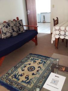 a living room with a blue couch and a rug at Biedouw Padstal & Toerisme in Clanwilliam