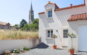 uma casa branca com uma igreja ao fundo em Nice Home In Saint-viaud With Kitchen em Saint-Viaud