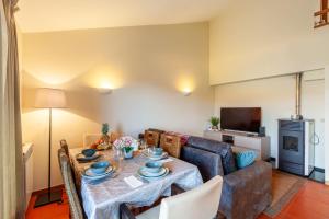 een woonkamer met een tafel en een bank bij Villa Martins - Minho's Guest in Vieira do Minho