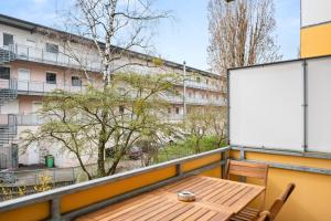 einen Tisch und Stühle auf einem Balkon mit einem Gebäude in der Unterkunft FREE LIVING - Jungle Design Apartments, Zentrum, Parkplatz, Küche, Wlan in Wolfsburg