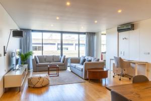 ein Wohnzimmer mit Sofa und Tisch in der Unterkunft Wave Break Apartment in Livramento