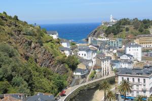 a town on a hill next to the ocean at Apartamentos turísticos Vistademar in Luarca