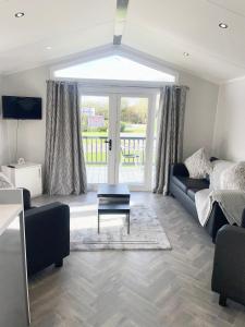 a living room with a couch and a table at Modern homely Chalet in Tuxford in Askham