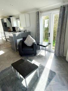 a living room with a couch and a table at Modern homely Chalet in Tuxford in Askham