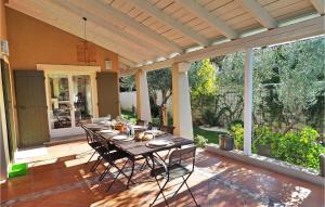 un patio avec une table et des chaises sur un porche dans l'établissement Mas De L'eveil, à Paradou