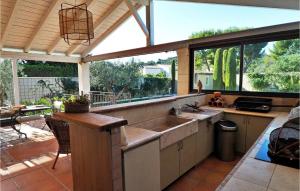 une cuisine avec un évier et une grande fenêtre dans l'établissement Mas De L'eveil, à Paradou