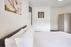 een witte slaapkamer met een bed en een kast bij Host & Stay - Clarendon Apartments in Redcar