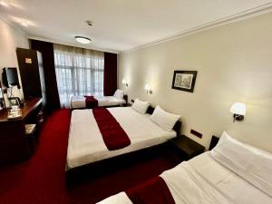 Habitación de hotel con 2 camas y escritorio en Hotel Hamburg, en Skopje