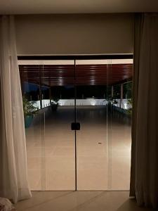 eine große Glastür in einem Zimmer mit Fenstern in der Unterkunft Casa de praia em Beberibe in Beberibe