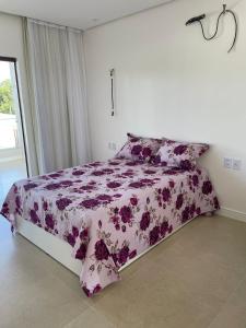 a bedroom with a purple and white bed with pillows at Casa de praia em Beberibe in Beberibe