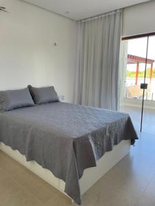 a bedroom with a large bed with a large window at Casa de praia em Beberibe in Beberibe
