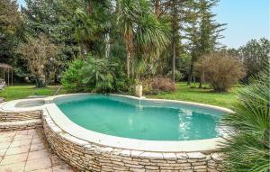 una piscina con una pared de piedra alrededor en Gorgeous Home In Entraigues-sur-la-sorg With House A Panoramic View, en Entraigues-sur-la-Sorgue