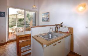 a kitchen with a sink and a table with an umbrella at 2 Bedroom Cozy Home In Grosseto-Prugna in Grosseto-Prugna