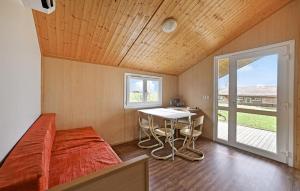 a bedroom with a bed and a table and a window at 2 Bedroom Stunning Home In Barjac in Barjac