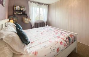 a bedroom with a bed with a floral bedspread at Amazing Home In Les Sables-D'olonne in Les Sables-dʼOlonne