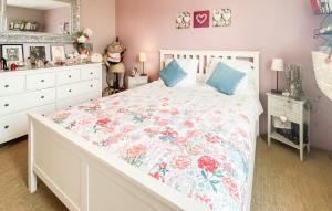 - une chambre avec un lit blanc et un couvre-lit floral dans l'établissement 3 Bedroom Amazing Home In Les Sables-dolonne, à Les Sables-dʼOlonne