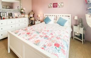 a bedroom with a white bed with a floral bedspread at Amazing Home In Les Sables-D'olonne in Les Sables-dʼOlonne