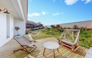 eine Veranda mit 2 Stühlen, einem Tisch und einer Schaukel in der Unterkunft Gorgeous Home In Bretignolles-sur-mer With House A Panoramic View in Brétignolles-sur-Mer
