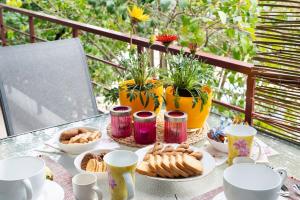 a table with cups and plates of food on it at Urban Bloom Oasis - Mini Zen Maison in Akovítika