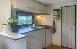 a small kitchen with a sink and a window at 1 Bedroom Cozy stacaravan In Putten in Putten
