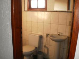 a bathroom with a toilet and a sink at Pousada Neves Paraiso Tropical in Barra de São João