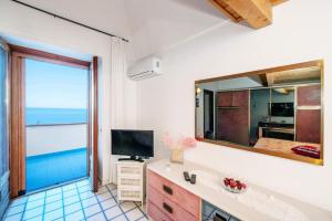 a bathroom with a large mirror and a television at Casa Rosamare, 150 steps from the road in Praiano