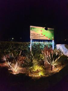 a sign in the middle of a garden at night at Appletorre House Holiday Flats in Torquay
