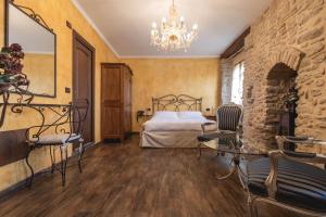 1 dormitorio con cama y lámpara de araña en Locanda dell'Ambra - Eleganza Rustica nel cuore della Romagna, en Talamello