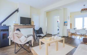 a living room with a fireplace and chairs and a tv at Gorgeous Home In Fléchin With Wi-Fi in FlÃ©chin