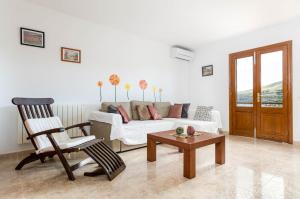 a living room with a couch and a chair at YourHouse Sol i Mar 2 beach apartment in Cala Mesquida