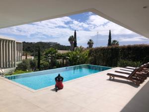un pingüino de plástico está parado junto a una piscina en Quinta Nova 103, en Alvor
