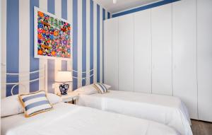 two beds in a room with blue and white stripes at Cozy Apartment In Chiavari With Wifi in Chiavari