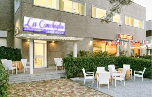 a restaurant with white tables and chairs in front of a building at Lovely Apartment In Deiva Marina in Deiva Marina