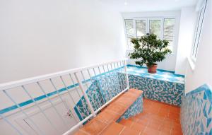 a staircase with blue and white tiles and a plant at Stunning Apartment In Deiva Marina in Deiva Marina +20 photos