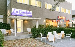 a restaurant with white tables and chairs in front of a building at Stunning Apartment In Deiva Marina in Deiva Marina