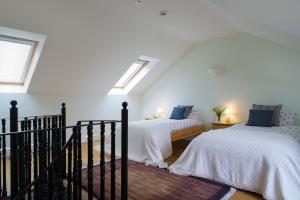 two beds in a white room with skylights at Ty Cellin Swyddffynnon in Ystrad-Meurig