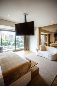 um quarto com uma cama e um sofá num quarto em Habitarte - Studio Luxo Brooklin em São Paulo