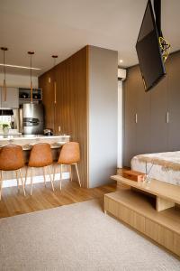 um quarto com uma cozinha com uma cama e cadeiras em Habitarte - Studio Luxo Brooklin em São Paulo
