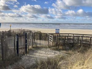 una valla en una playa con el océano en Studio Berck-Plage, 1 pièce, 2 personnes - FR-1-646-33, en Berck-sur-Mer