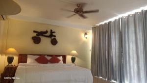 a bedroom with a bed and a ceiling fan at Homestay Yellow Natural House in Siem Reap