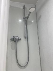 a shower with a shower head on a wall at Duloch Bridge View in Dunfermline