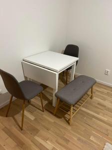 una mesa blanca y 2 sillas en una habitación en Cozy apartment 2 stops-15 mins away from city center, en Estocolmo