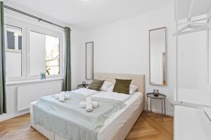 um quarto branco com uma cama grande e 2 janelas em FeelHome-Balkon-Zentrum-6 Gäste-WiFi-Smart TV em Viena