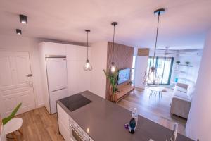 cocina y sala de estar con sofá y TV en Apartasuites Royal Zahara, Máximo confort con vistas al mar, en Zahara de los Atunes