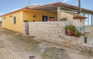 a yellow house with a stone wall next to it at Stunning Home In Ragusa With Wifi in Ragusa +15 photos