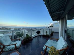 a balcony with chairs and a view of the ocean at Mountainside Sea View Apartment In Muizenberg in Cape Town